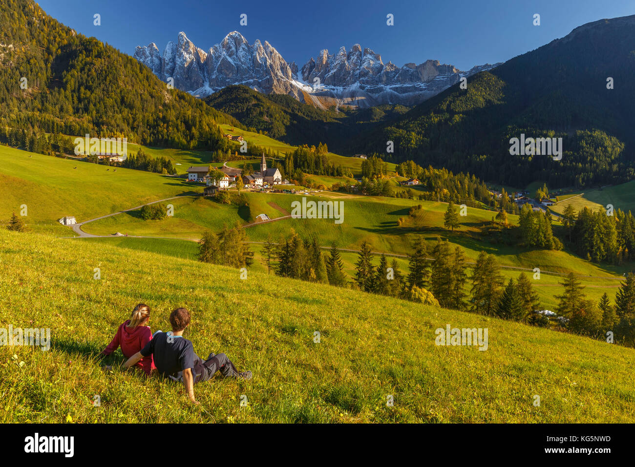 Two brothers admires the village of Santa Magdalena, Funes valley, Odle dolomites, South Tyrol region, Trentino Alto Adige, Bolzano province, Italy, Europe Stock Photo