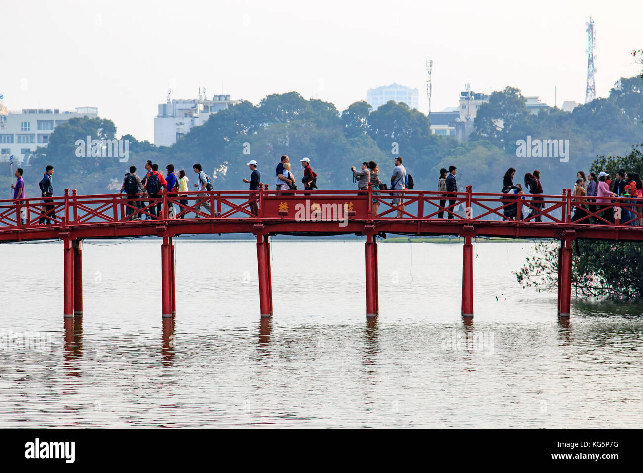 People walking on the Huc Bridge over the Hoan Kiem Lake Stock Photo