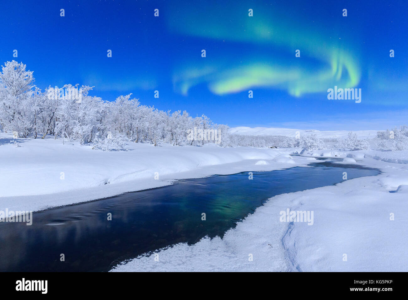 During a full moon night, the northern lights appear in the sky above a river. Riskgransen, Norbottens Ian, Lapland, Sweden, Europe Stock Photo