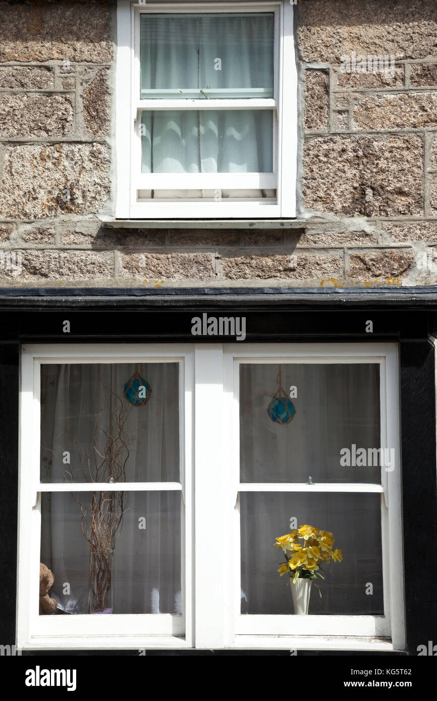 Yellow flowers adorn a window in Saint Just, Cornwall, England. Stock Photo