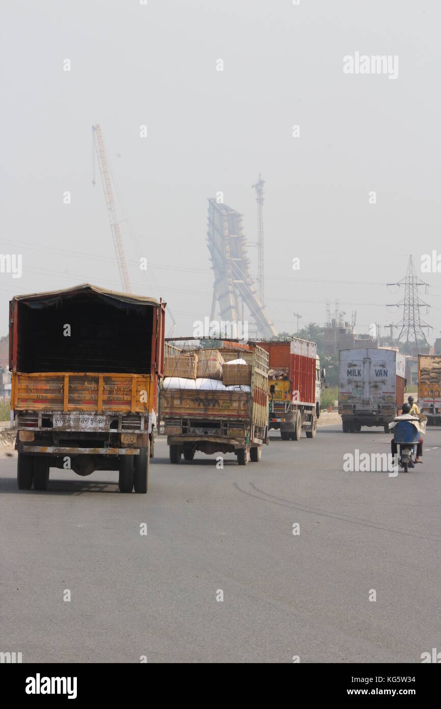 Commercial vehicles on outer ring road in Delhi. Under construction Signature Bridge on the river Yamuna at Wazirabad is also visible Stock Photo