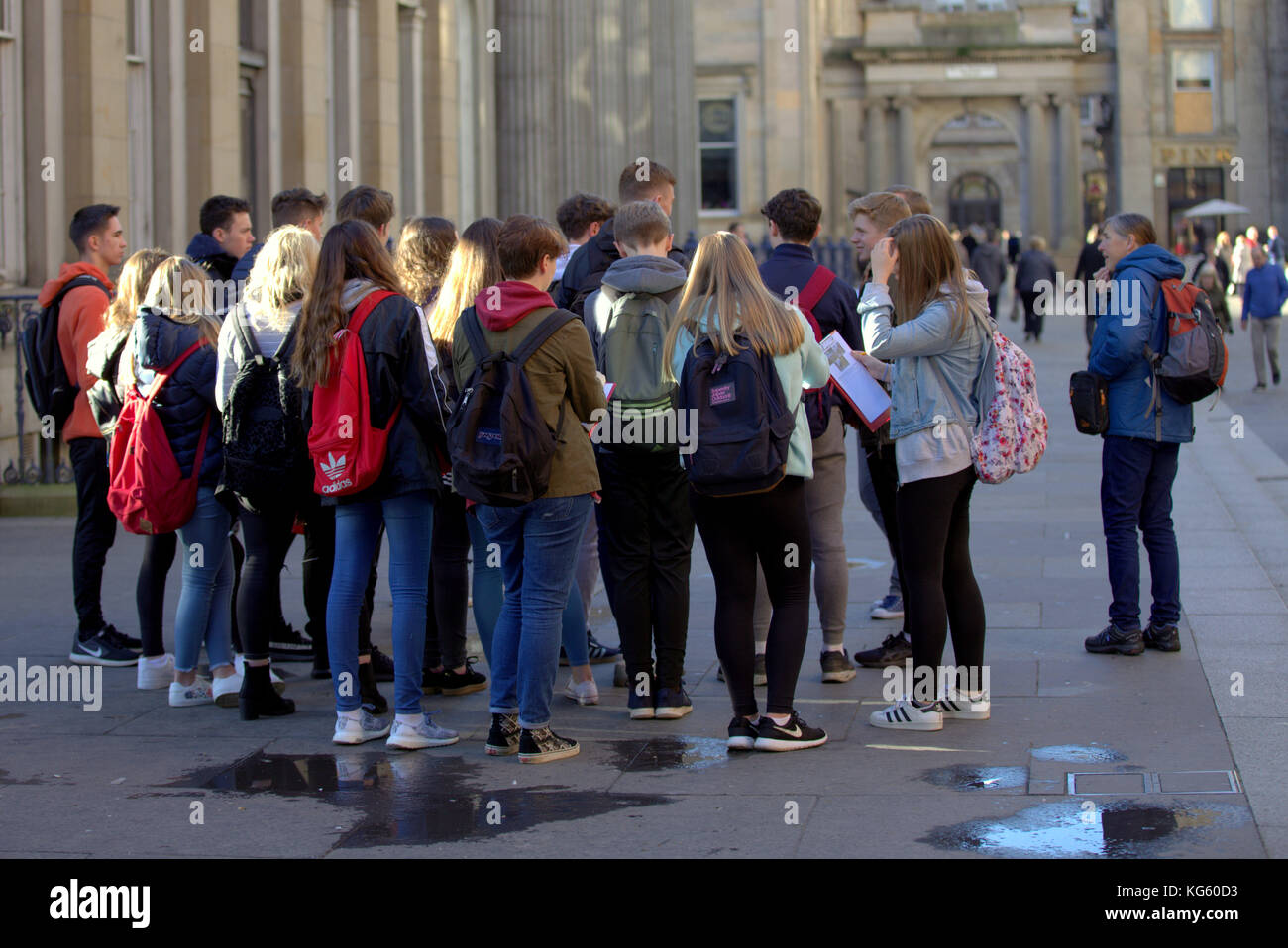 large group of schoolchildren  foreign students on street together viewed from behind in royal exchange square goma Stock Photo