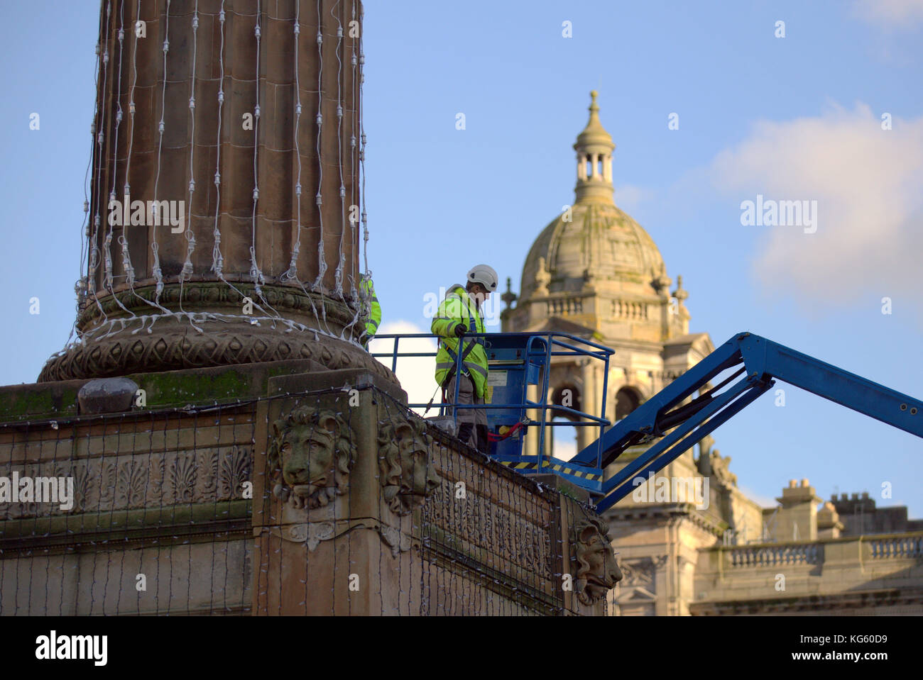 Council workers signal the arrival of the festive season as they prepare t decorations for the christmas  lights in the town's George Square. Stock Photo