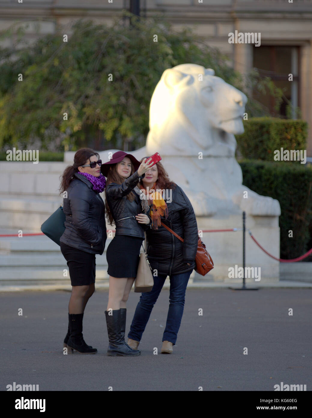 three women girls taking selfie photograph the  lion on the cenotaph on george square glasgow Stock Photo