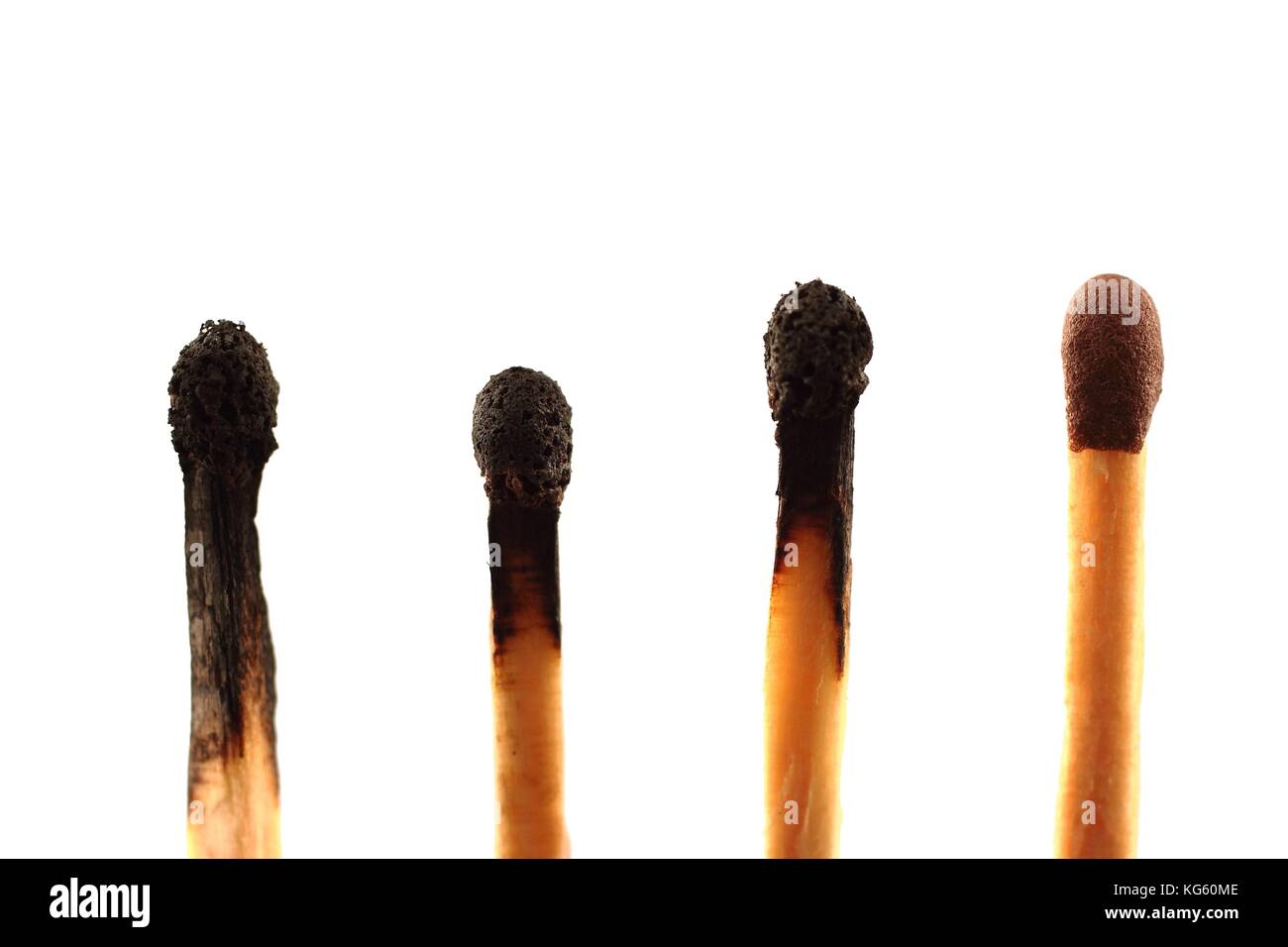 Four matches - three used and one unused - against a white background in landscape format with copy space Stock Photo