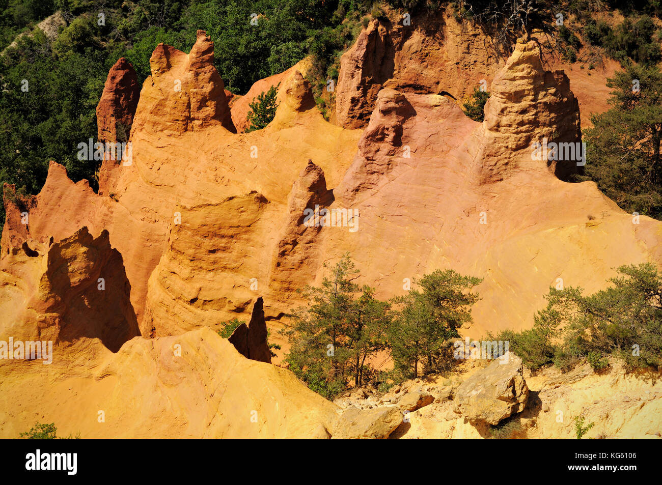 Ochre cliff and trees in Colorado Provencal, Rustrel, Vaucluse, France Stock Photo