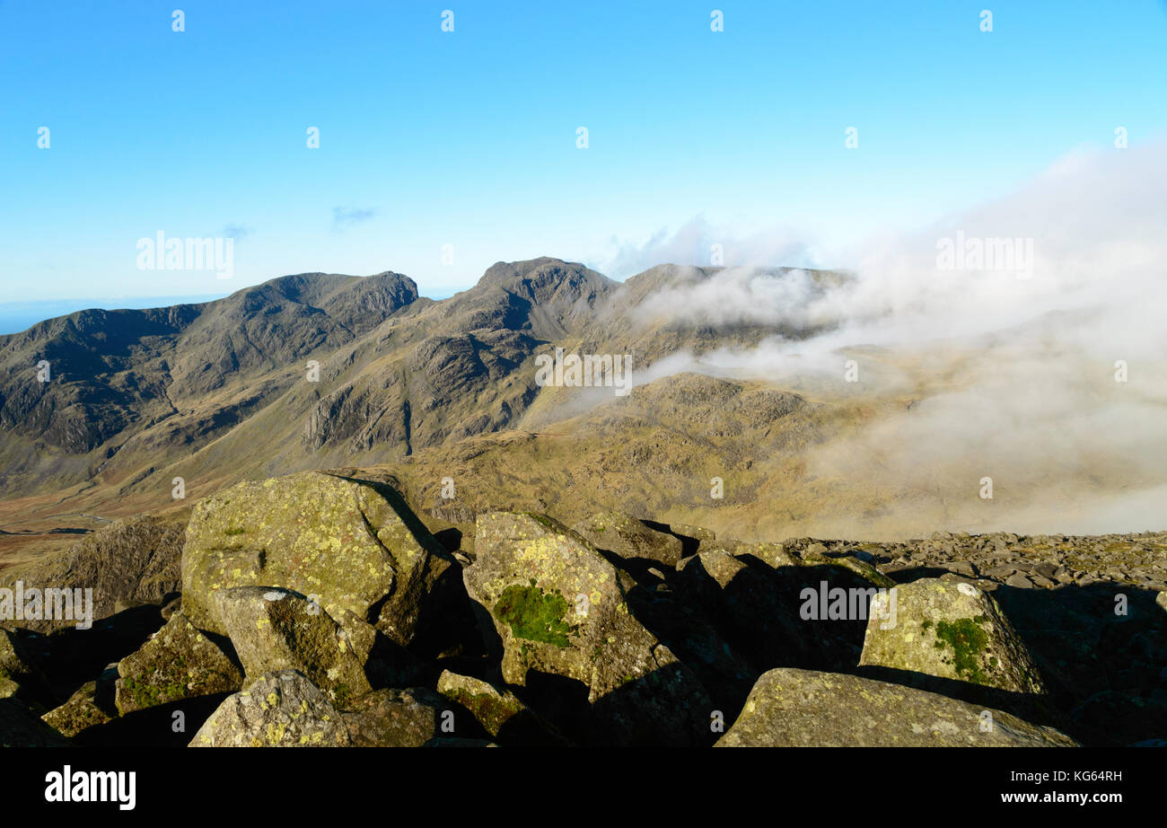 Scafell Pike and Scafell from Bowfell in The English Lake District in clearing mist. Stock Photo