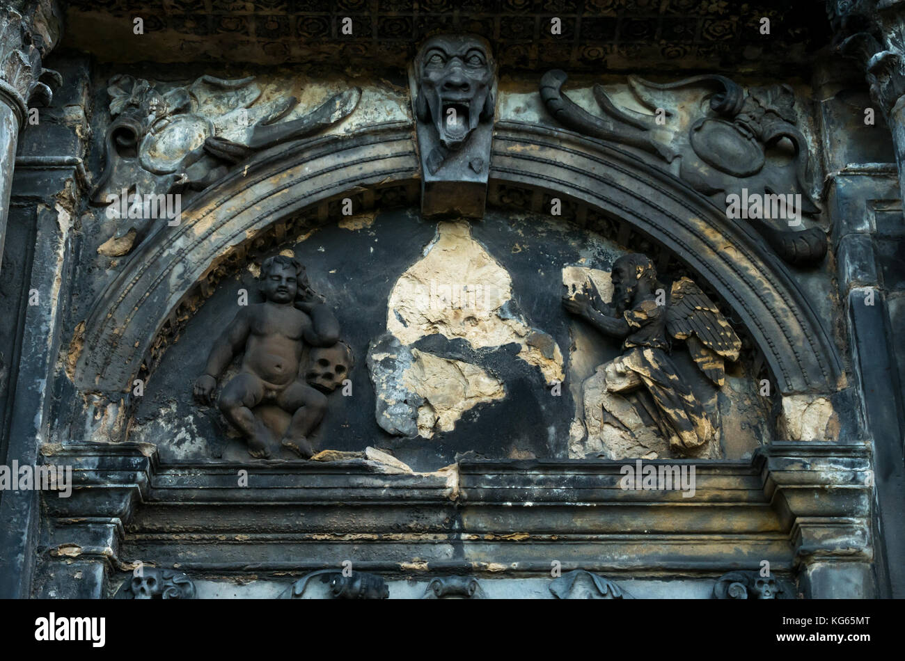 Close up of old worn Victorian tomb with carved cherub with cherub, angel, skull and face, Greyfriar's churchyard, Scotland, UK Stock Photo
