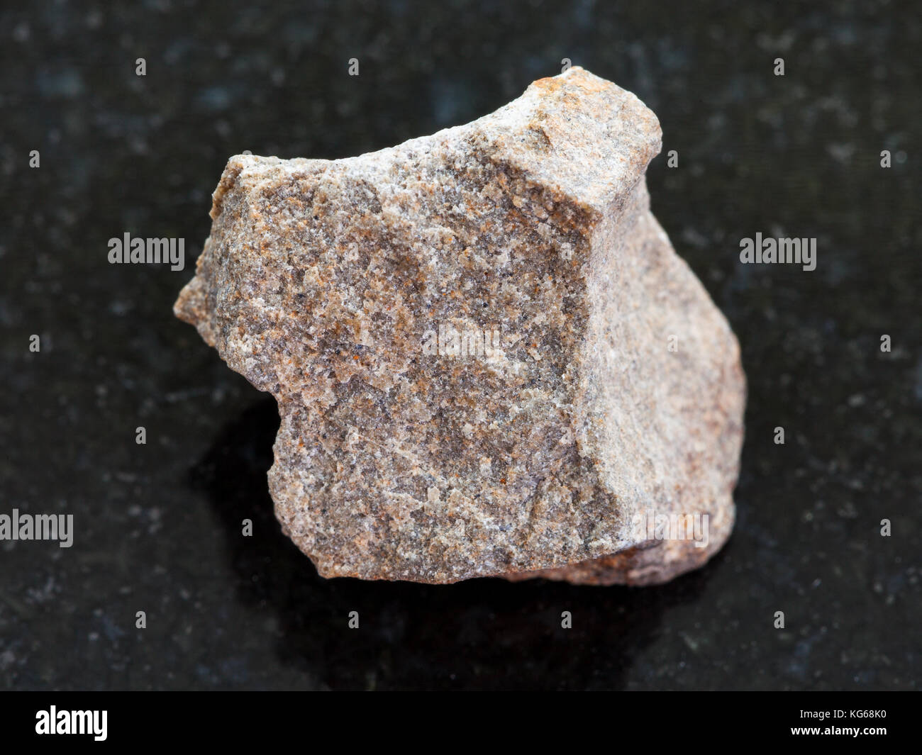 macro shooting of natural mineral rock specimen - rough Quartzite stone on dark granite background Stock Photo