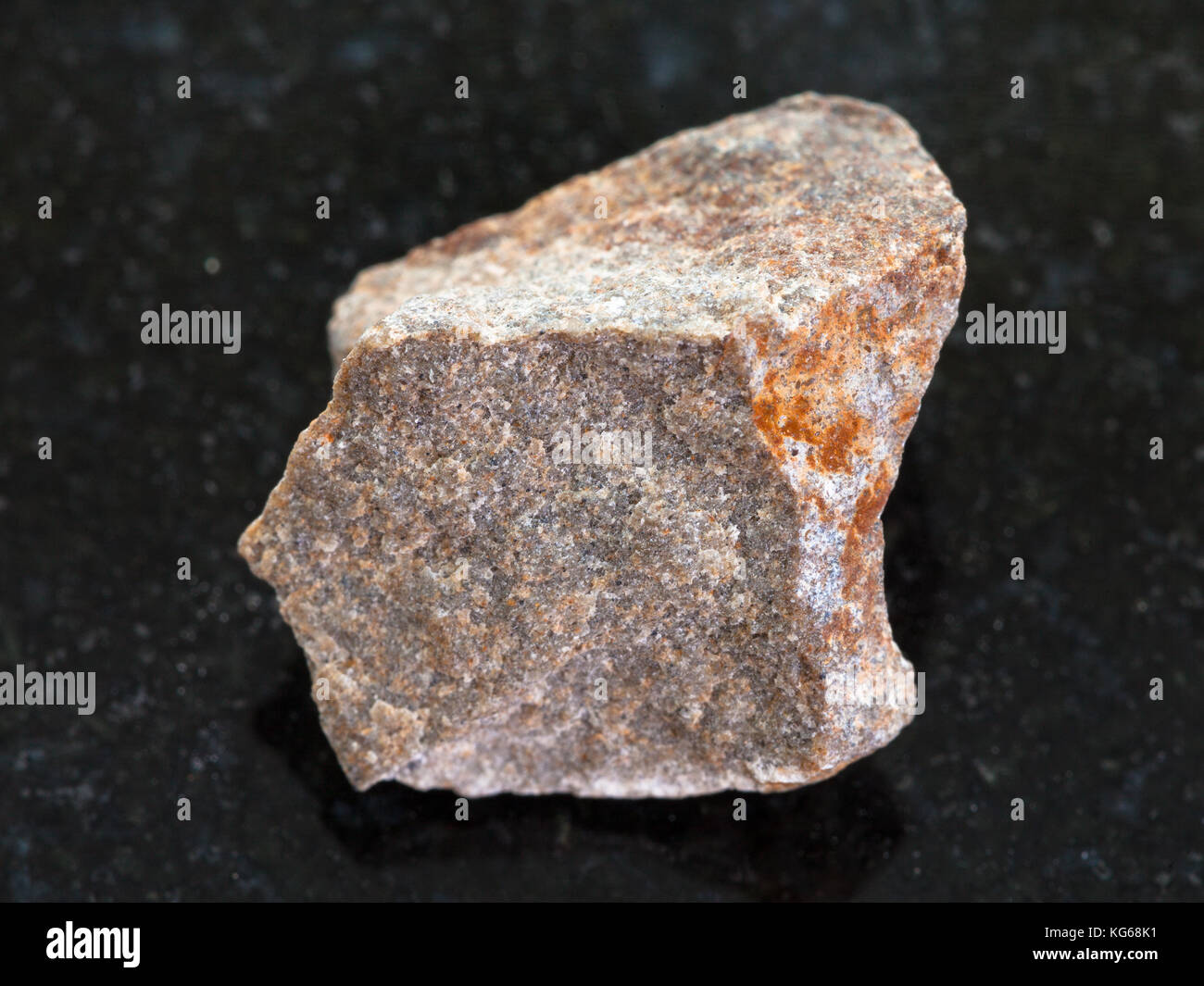macro shooting of natural mineral rock specimen - raw Quartzite stone on dark granite background Stock Photo