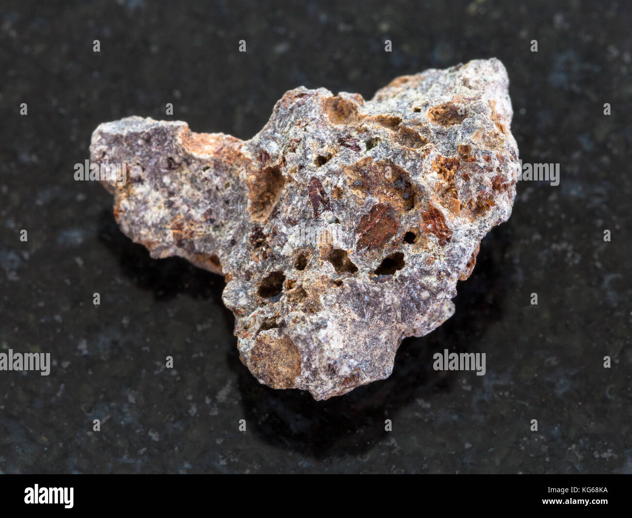 macro shooting of natural mineral rock specimen - Basalt stone on dark granite background Stock Photo