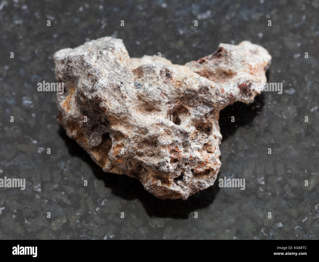 macro shooting of natural mineral rock specimen - raw Basalt stone on dark granite background Stock Photo