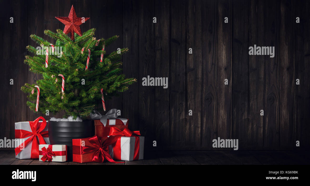 Decorated Christmas tree with candy canes and gift boxes on wooden ...