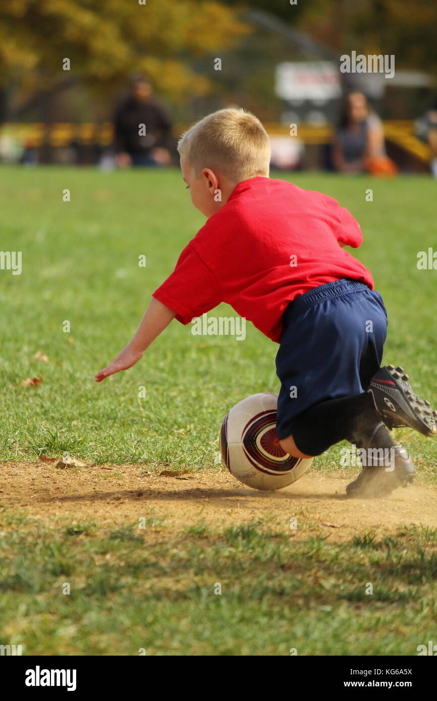 Little boy taking a fall on the soccer field Stock Photo