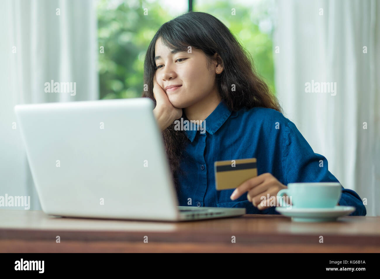 asia woman online shopping using credit card with laptop computer on wood table at cafe restaurant,Digital lifestyle concept Stock Photo