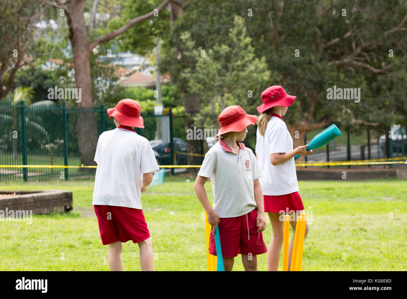 Australian schools children playing cricket sport at school,Sydney,Australia wearing red and white school sports uniform Stock Photo