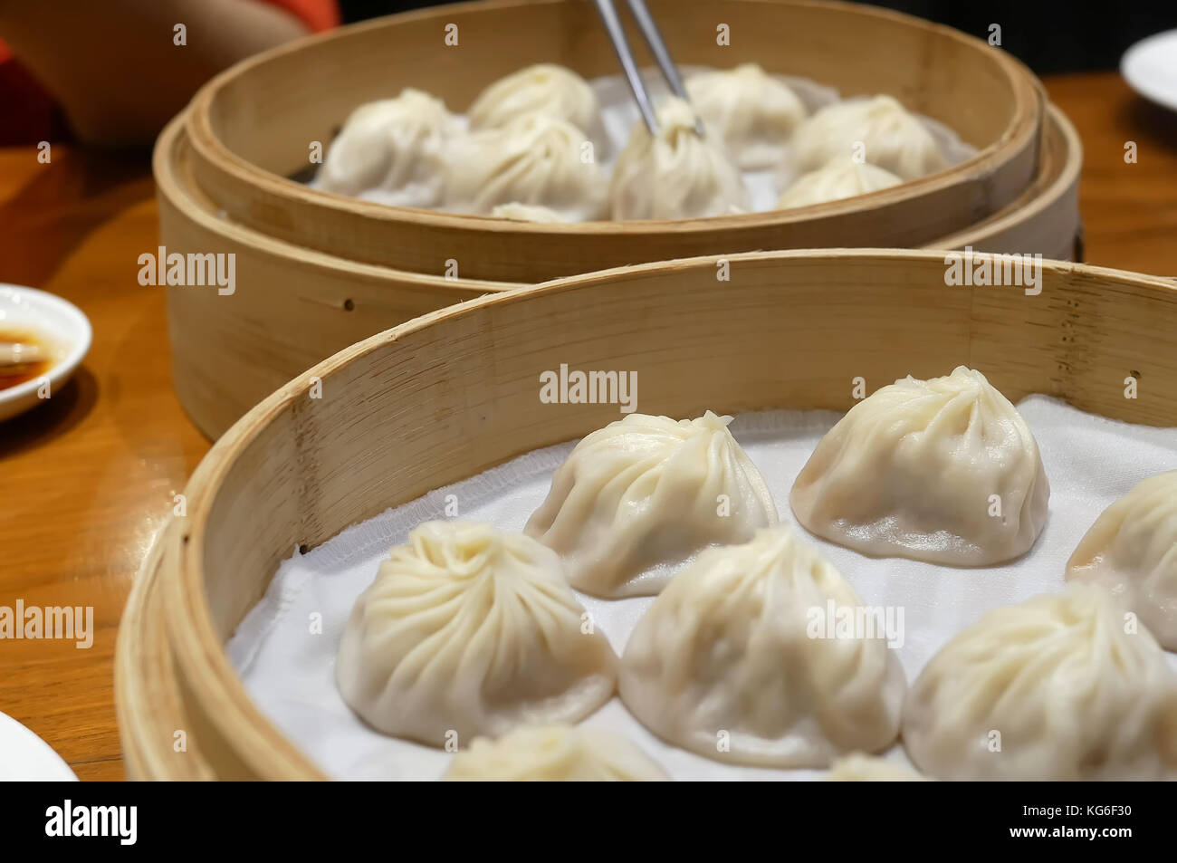 Motion of woman eating soup dumpling buns with chopsticks inside