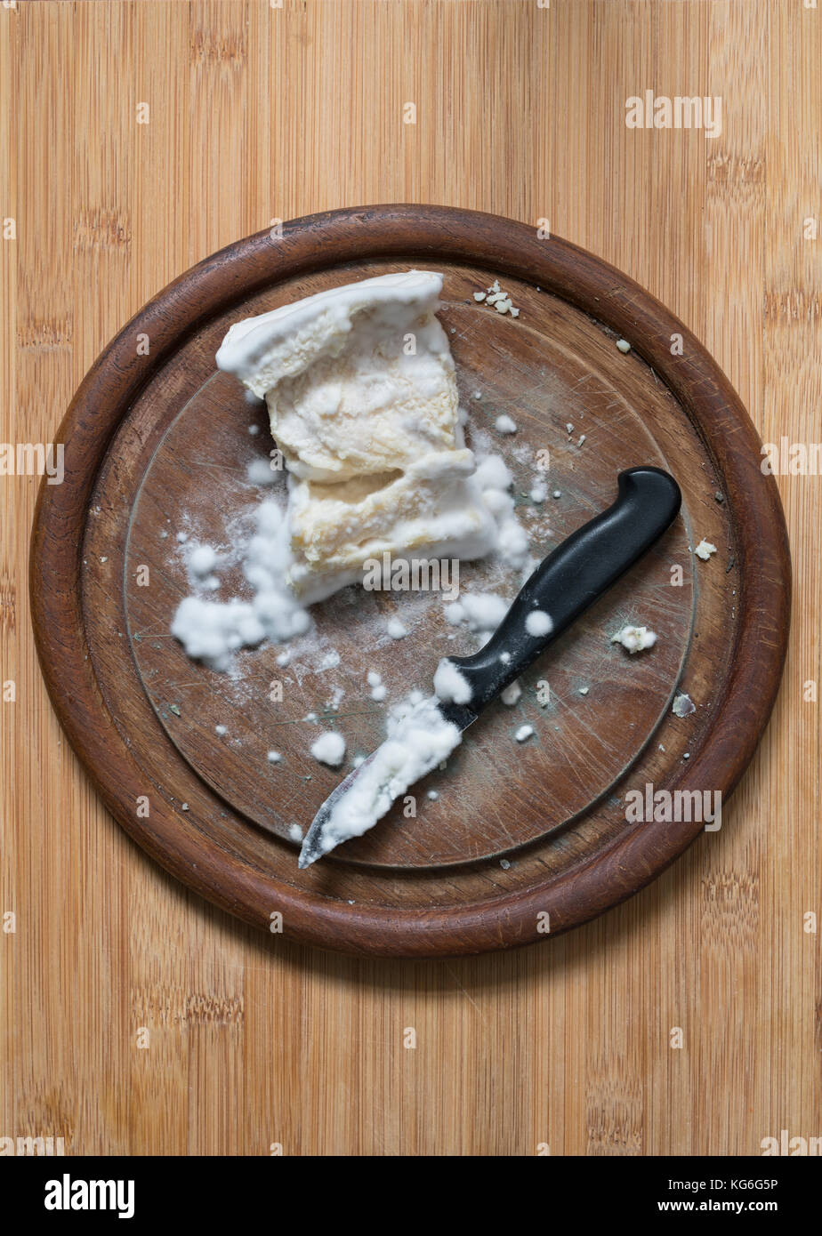 Moldy goats cheese and knife on a wooden cheese board Stock Photo
