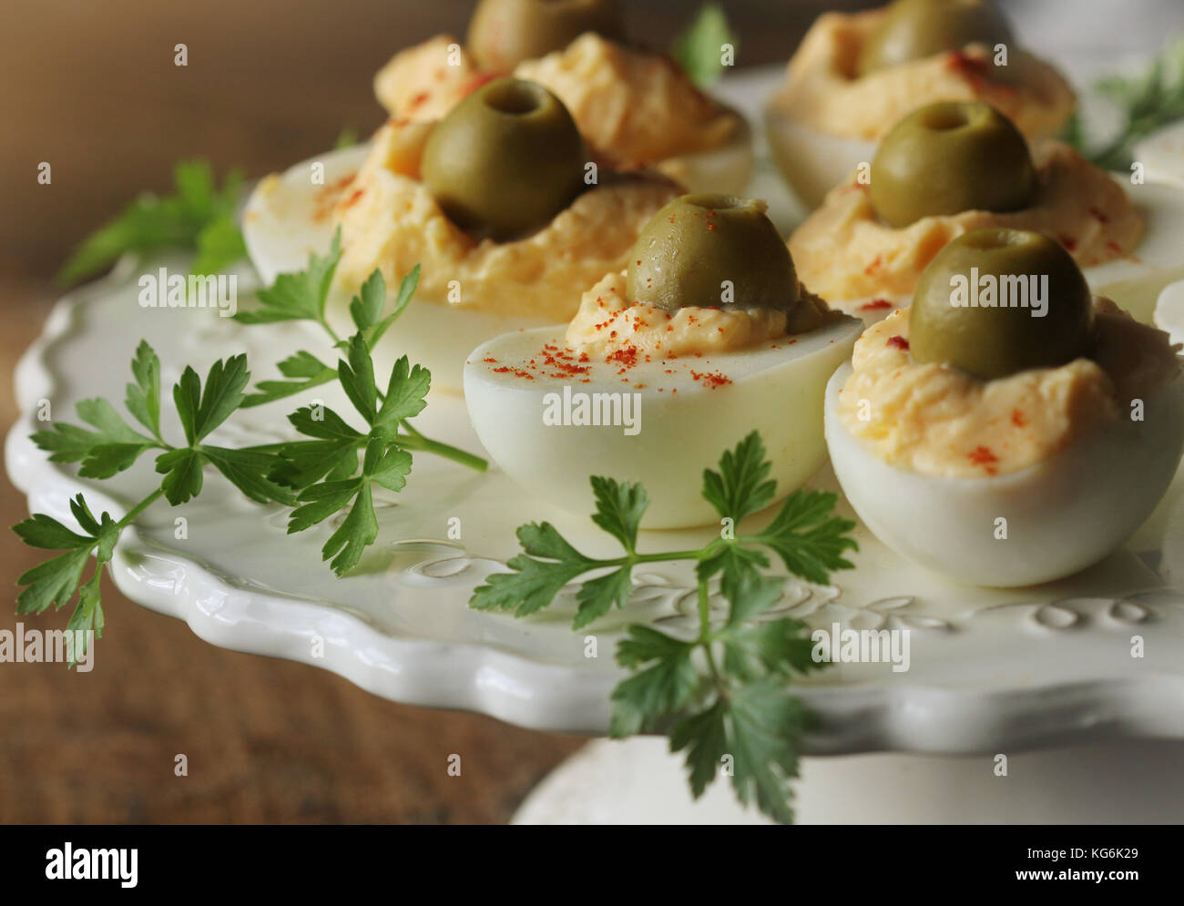 Spicy deviled eggs garnished with green olives and pepper Stock Photo
