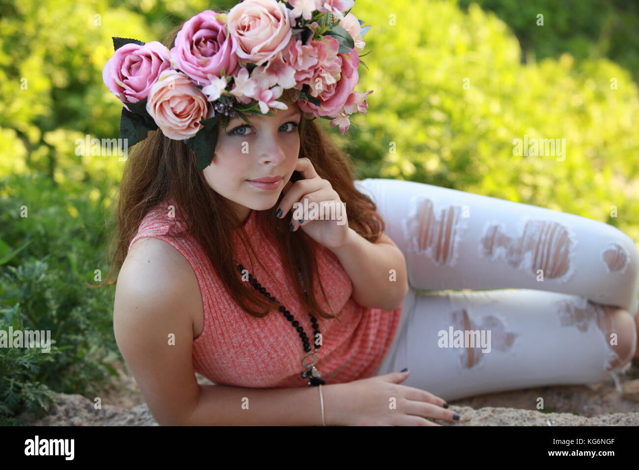A young beautiful woman in the spring wearing fashionable cloths and a floral crown Stock Photo