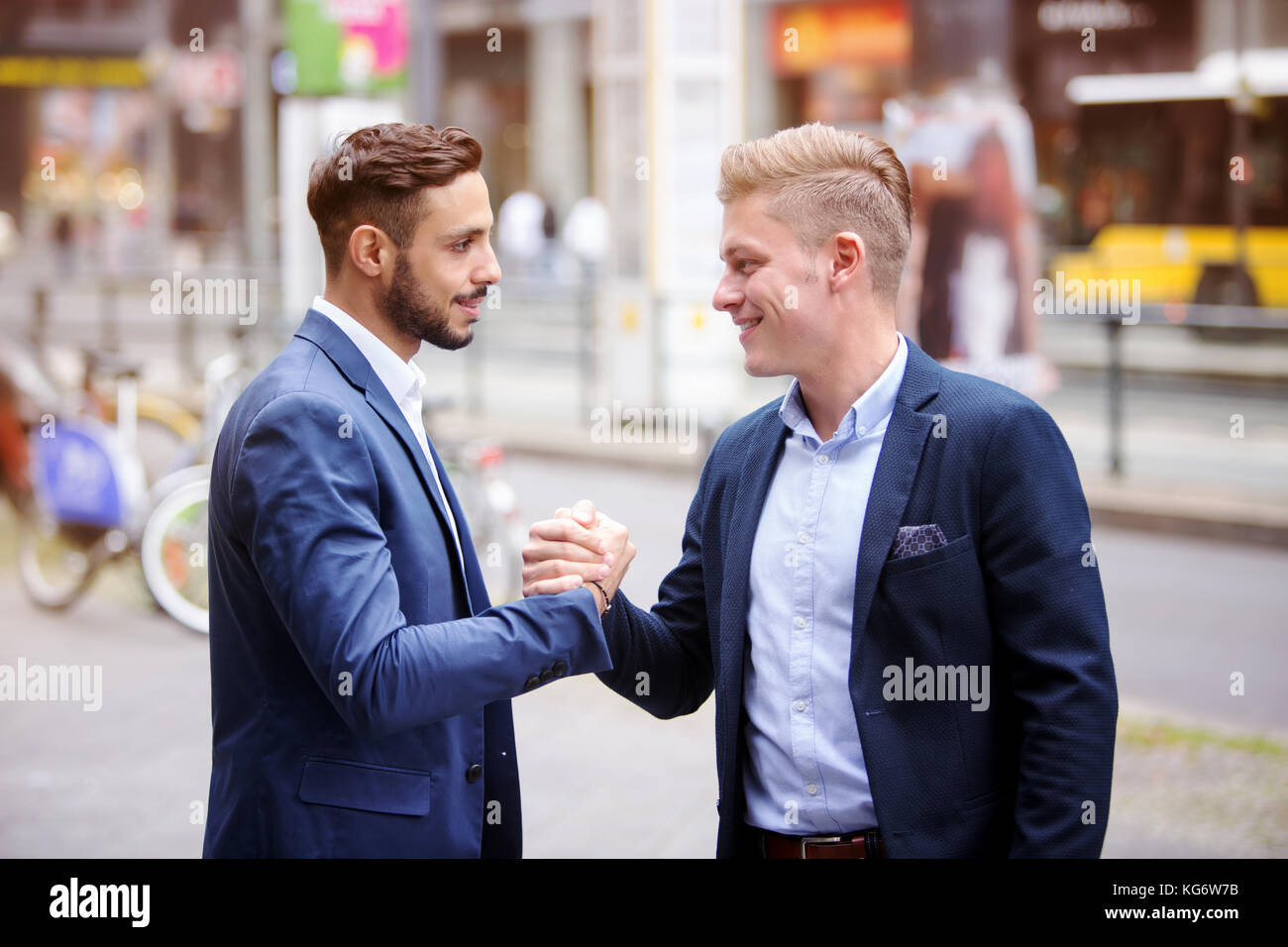 two handsome businessmen greeting each other in the street Stock Photo ...