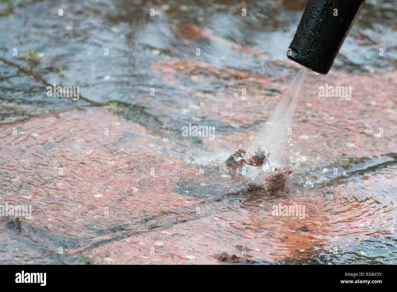 pressure washer being used badly causing damage to mortar on patio Stock Photo