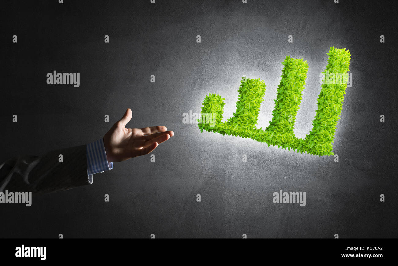 Close of businessman hand and green growing graph as symbol of progress ...