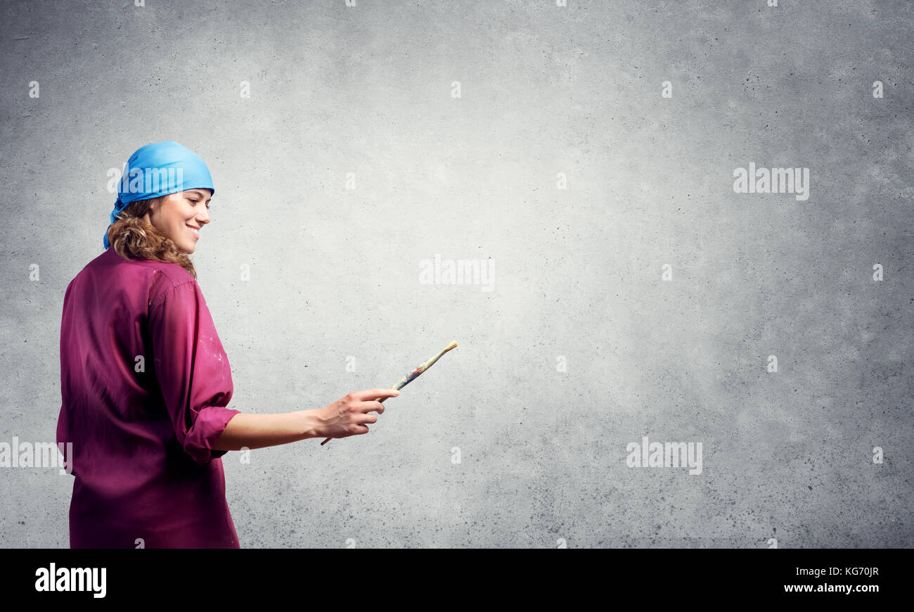 Young pretty artist woman with paint brush in hand Stock Photo - Alamy