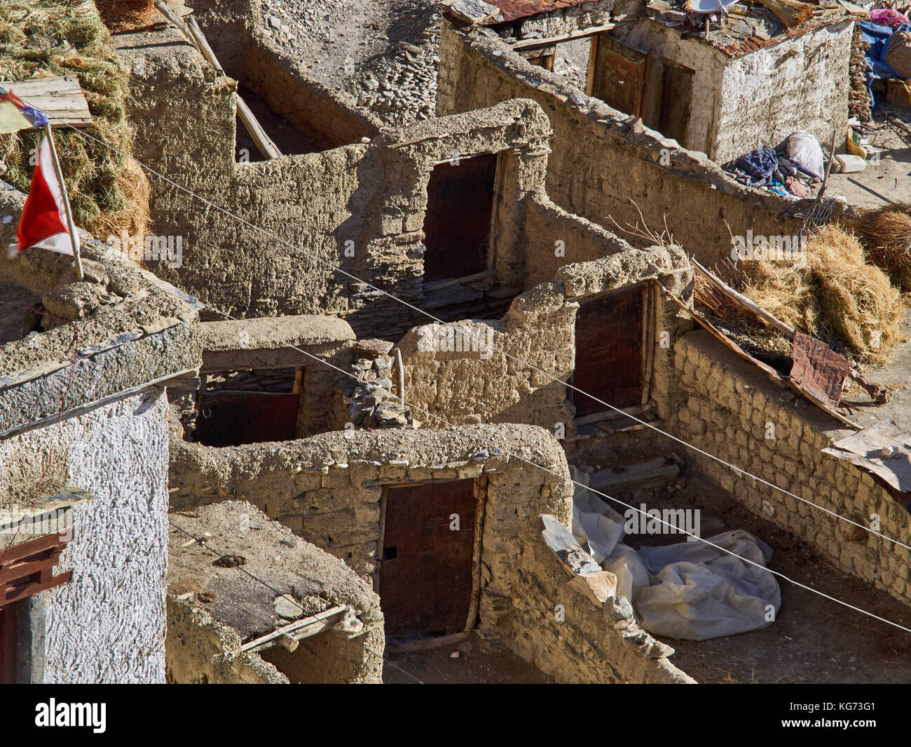 Tibetan village, labyrinth walls of clay brick, brown doors in the walls, the Himalayas