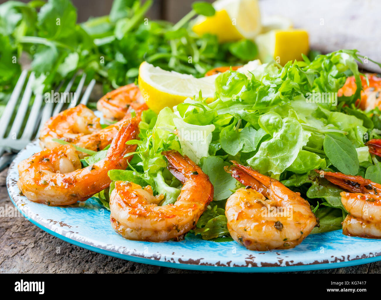 Seafood shrimp prawns. Srimp lettuce salad on blue plate with lemon