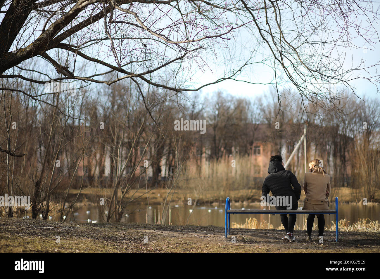 A pair of friends are sitting in an autumn park on a bench Stock Photo ...