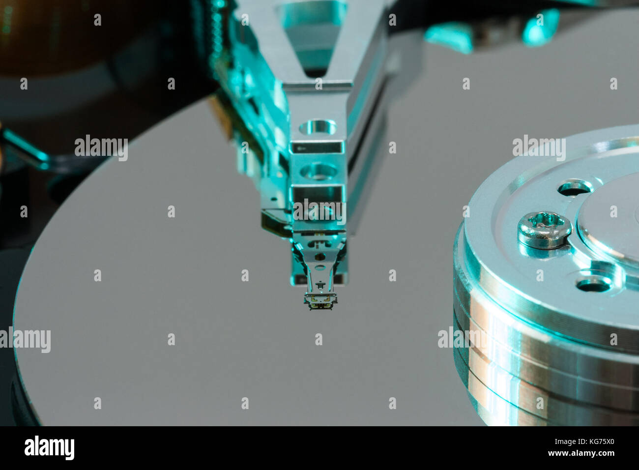 Close up inside of a computer harddrive with reflections of the read ...