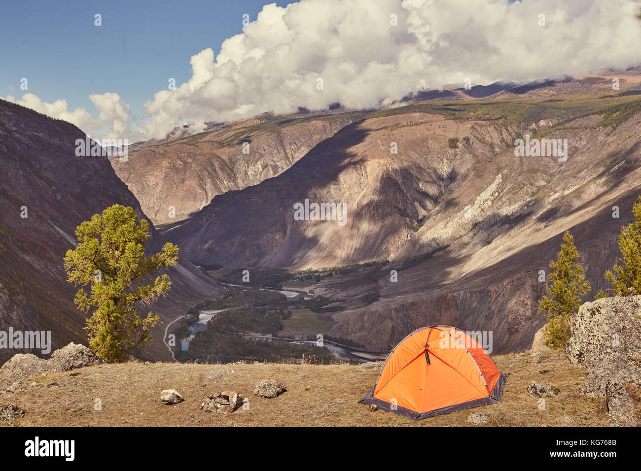 An orange tent at the edge of canyon Stock Photo