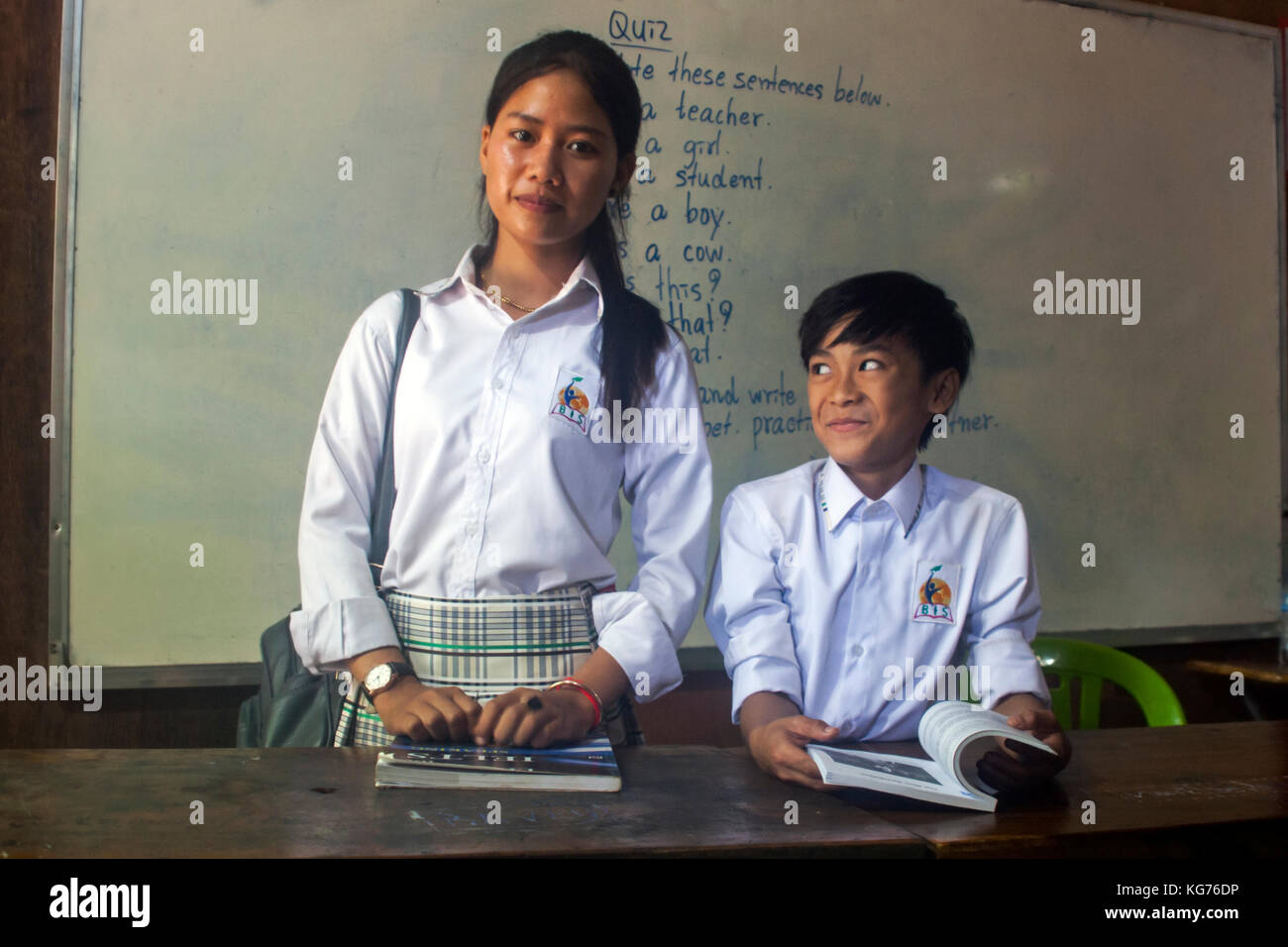 A boy and a girl student are standing inside a classroom wearing school uniforms at an English language school in Tboung Khmum province, Cambodia. Stock Photo