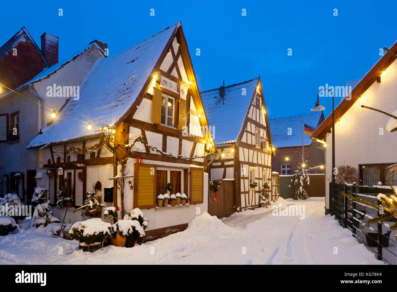 An old village street with half-timbered houses and christmas lights at night during snowfall in Lachen, Neustadt an der Weinstrasse, Germany. Stock Photo