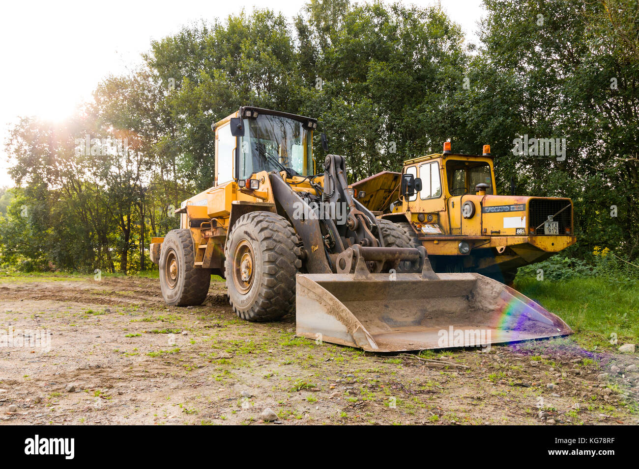 Volvo BM front loader scooping up rainbow looking reflection  Model Release: No.  Property Release: No. Stock Photo