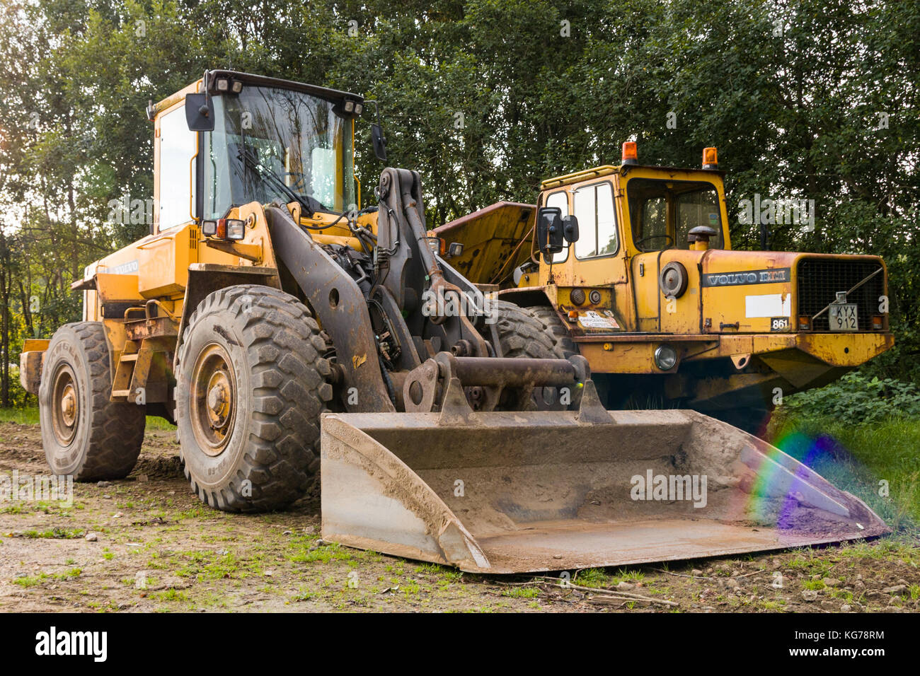 Volvo BM front loader scooping up rainbow looking reflection  Model Release: No.  Property Release: No. Stock Photo