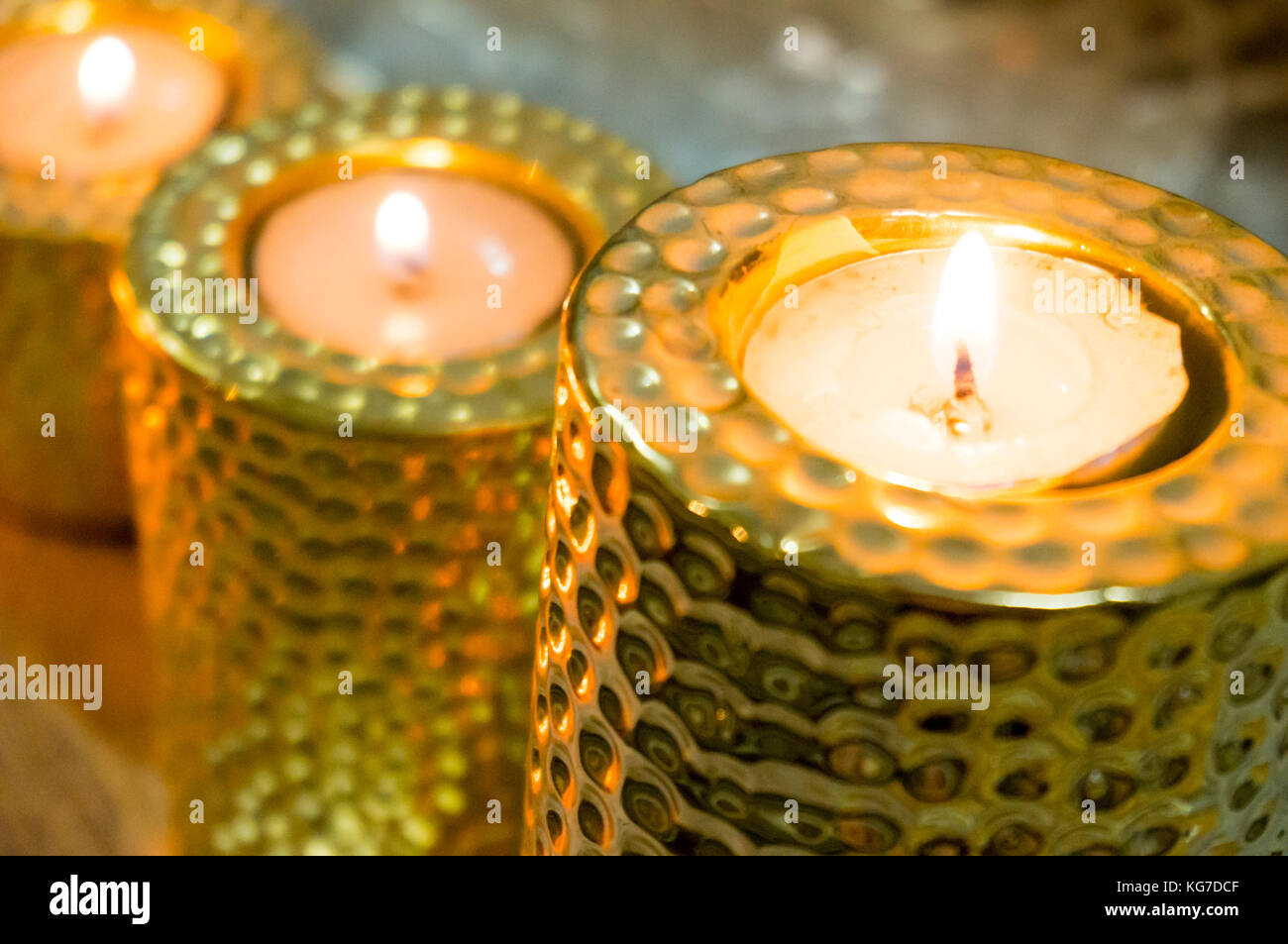 Beautiful golden candle holders with tea lights placed on them. Perfect for home office decoration with scented candles Stock Photo