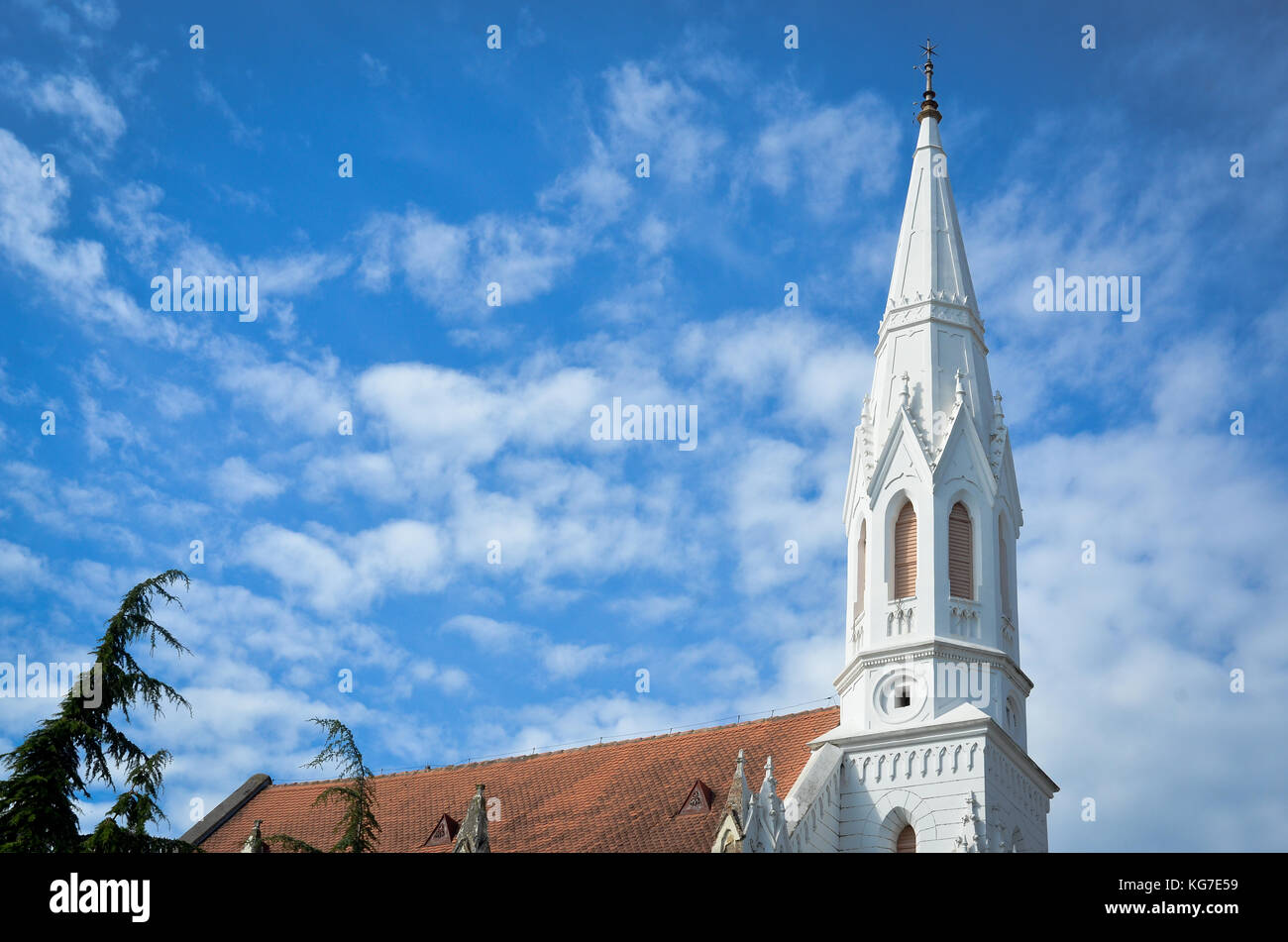 white Catholic cathedral on sunny day with blue sky and clouds ...
