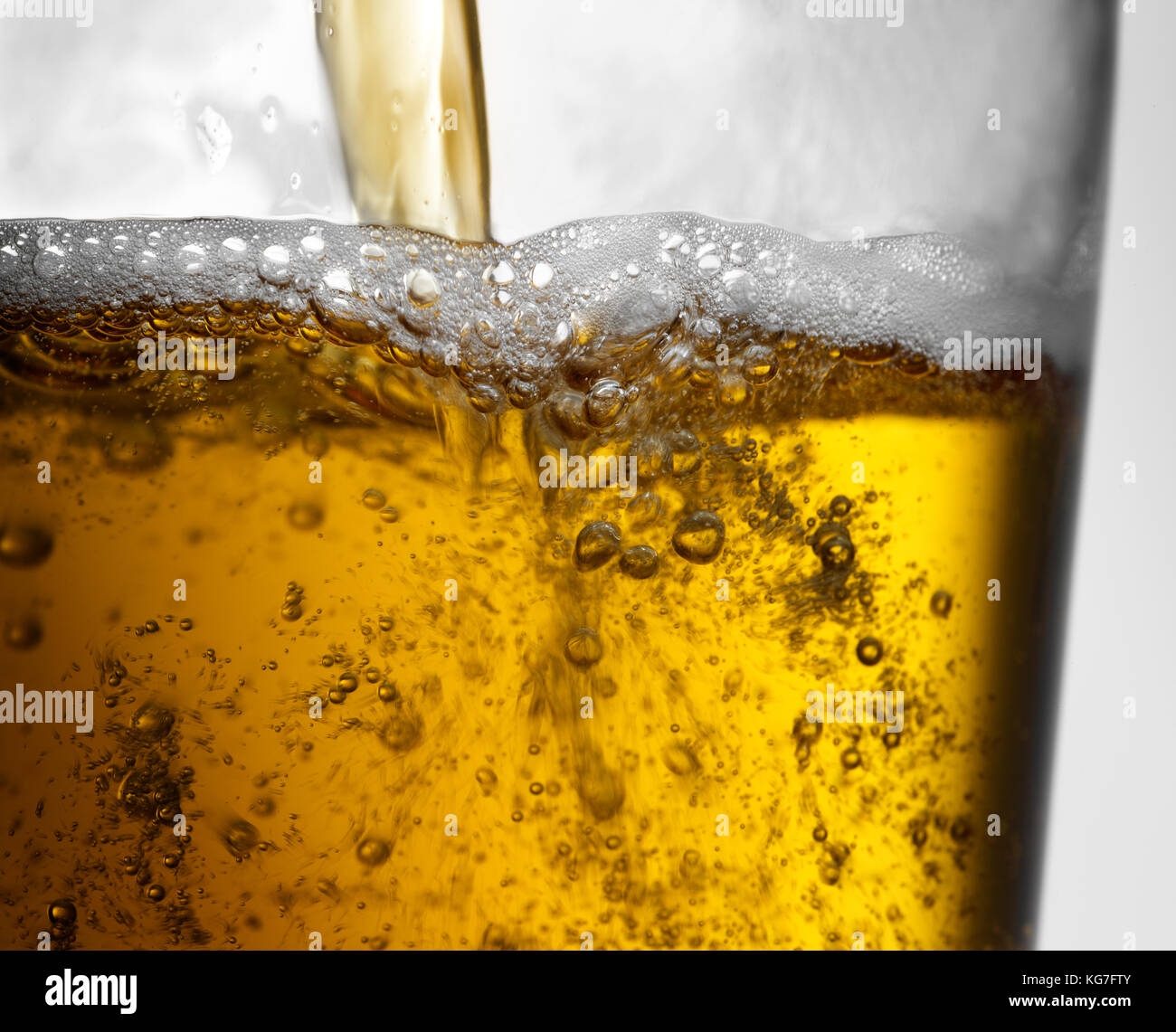Beer pour into clear glass with bubbles and frothy head Stock Photo Alamy