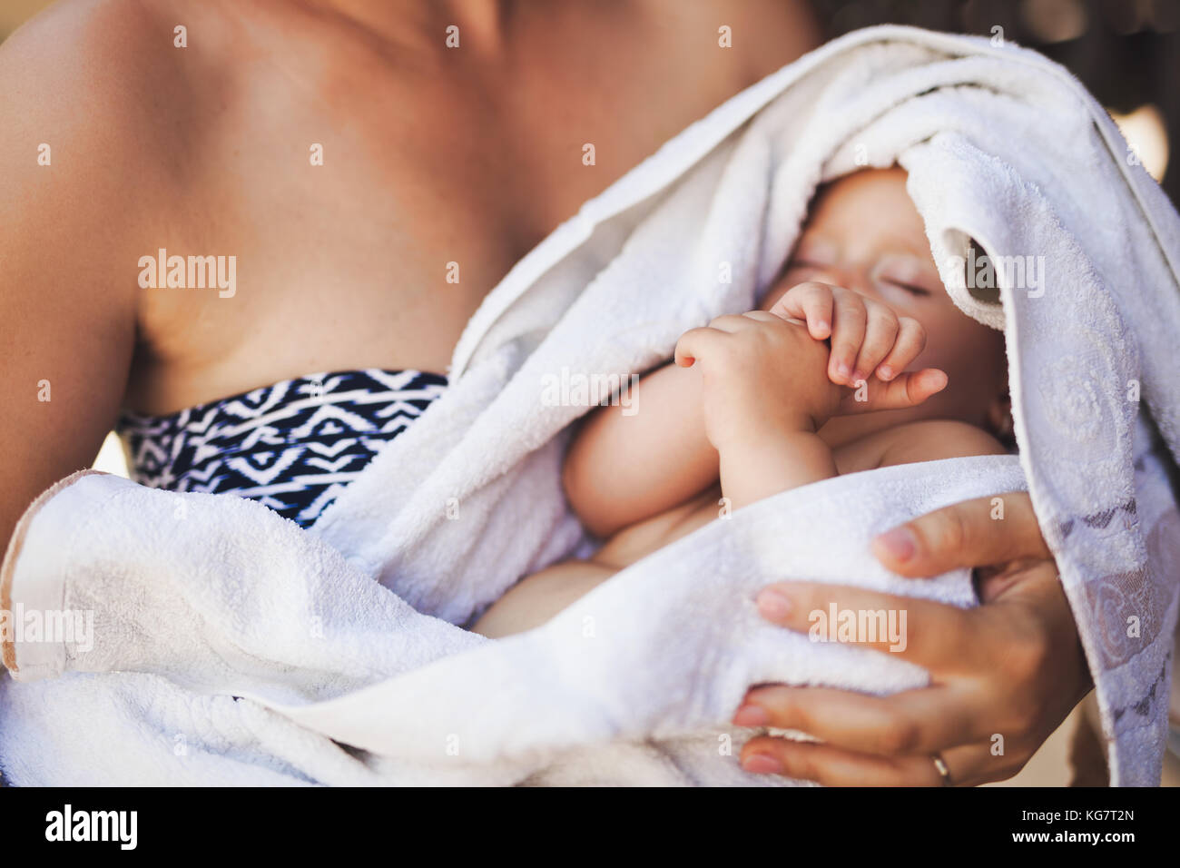 Young mother holding her sleeping newborn baby Stock Photo