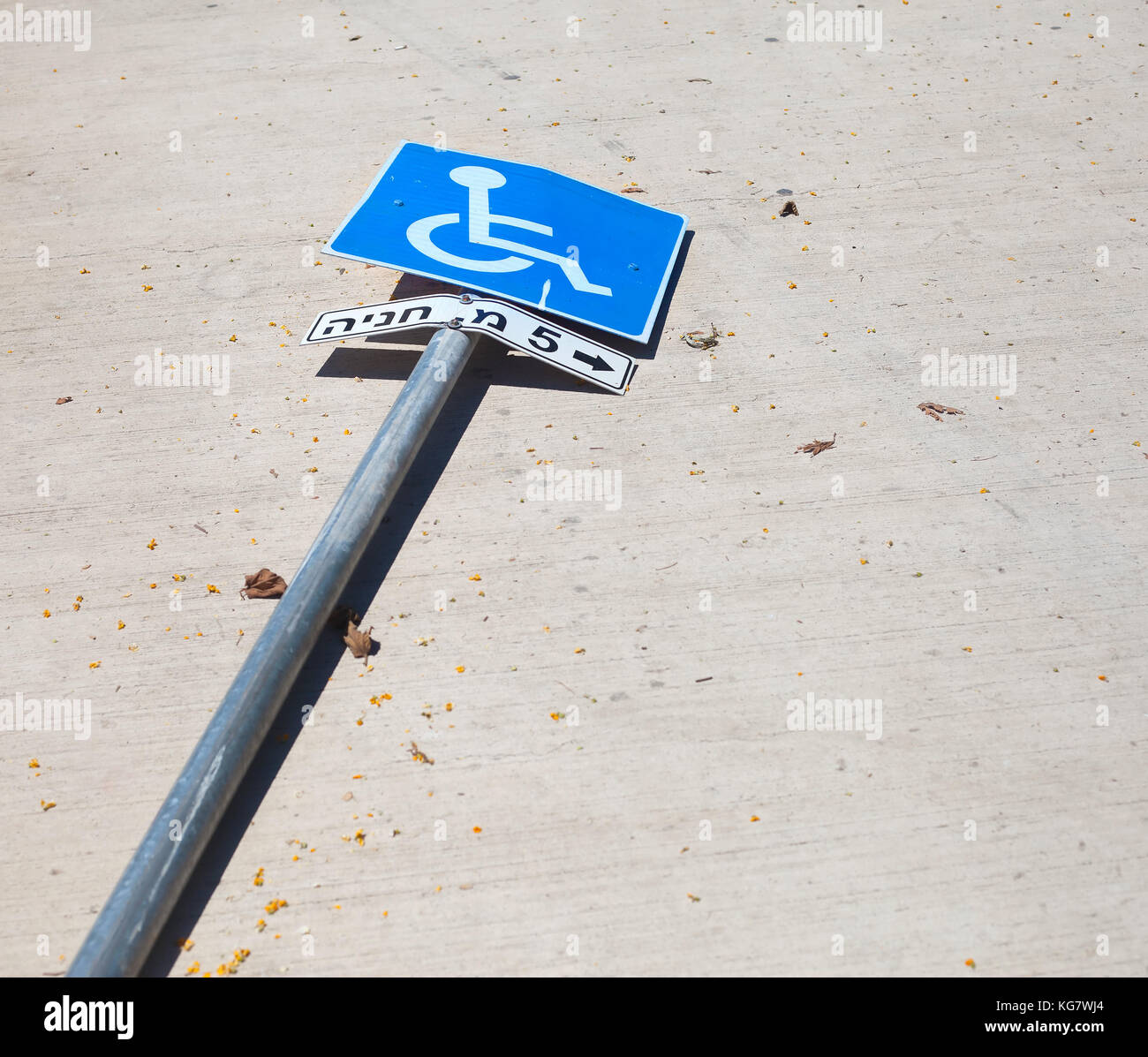 Reserved parking sign knocked over on the road. The letters in Hebrew read 'Parking 5 m' Stock Photo