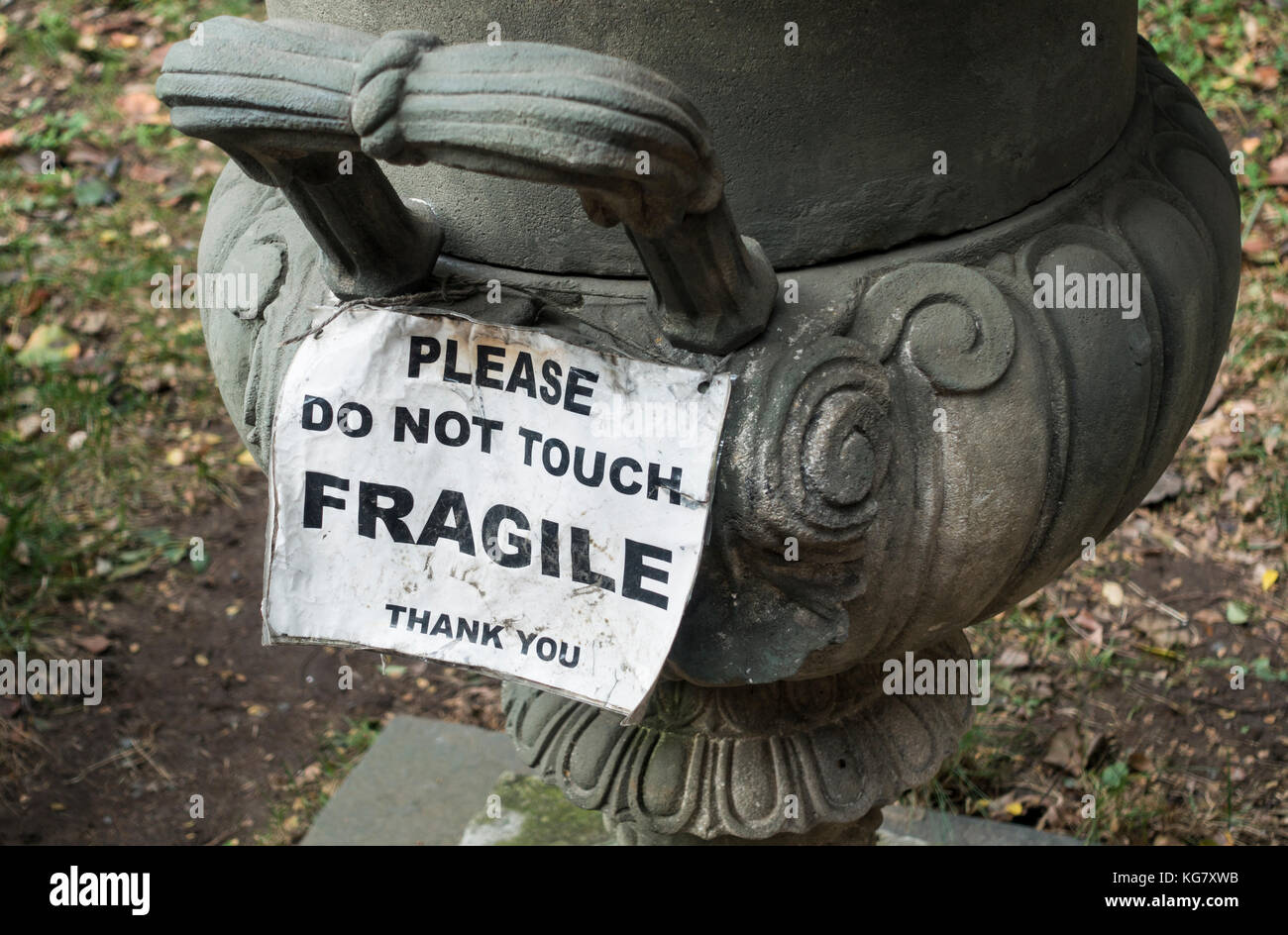 Warning sign on a large antique bowl in Elizabeth Street Park in Nolita in New York City Stock Photo