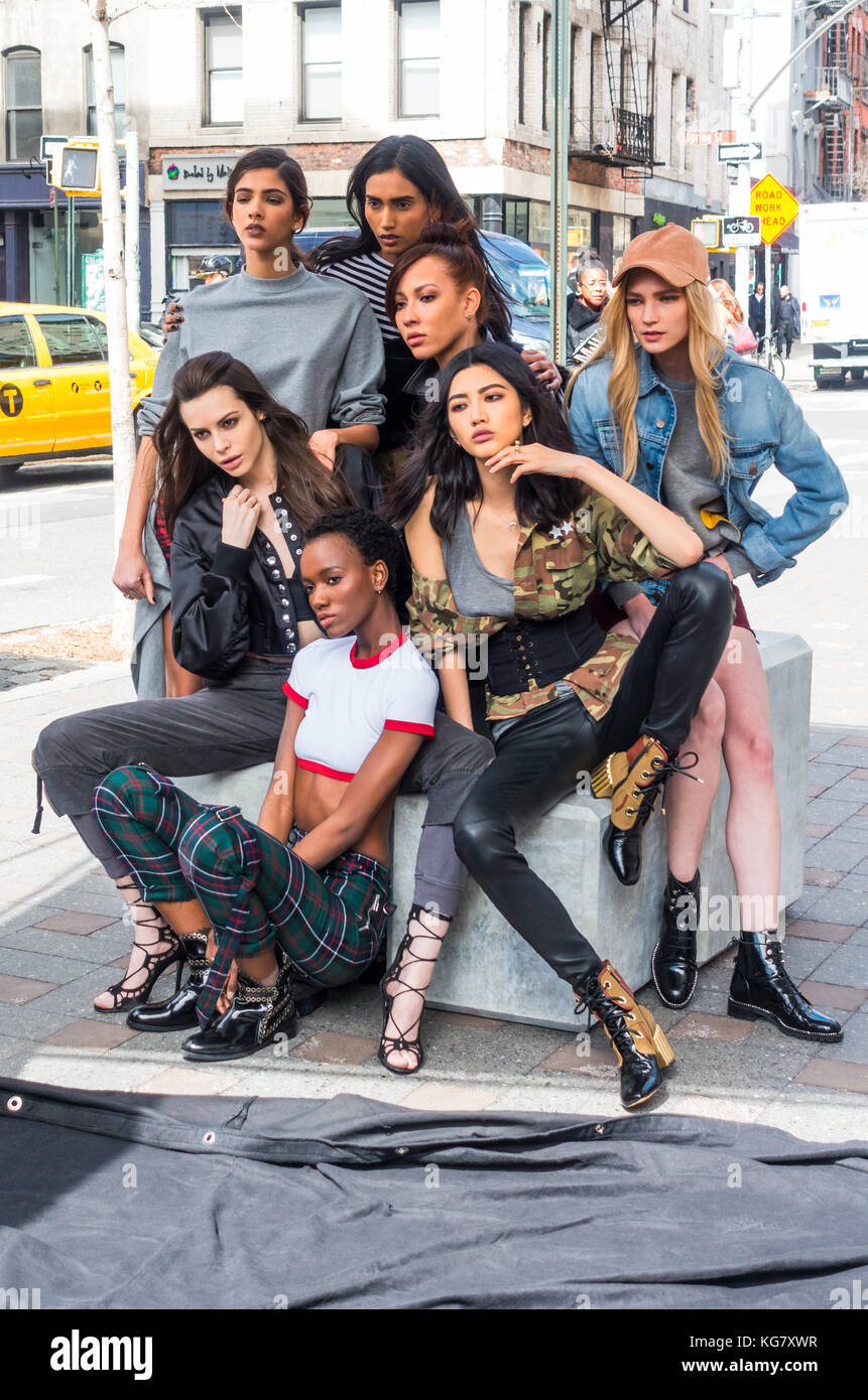 Seven female models posing for a photographer on a SoHo street in New York City, US Stock Photo