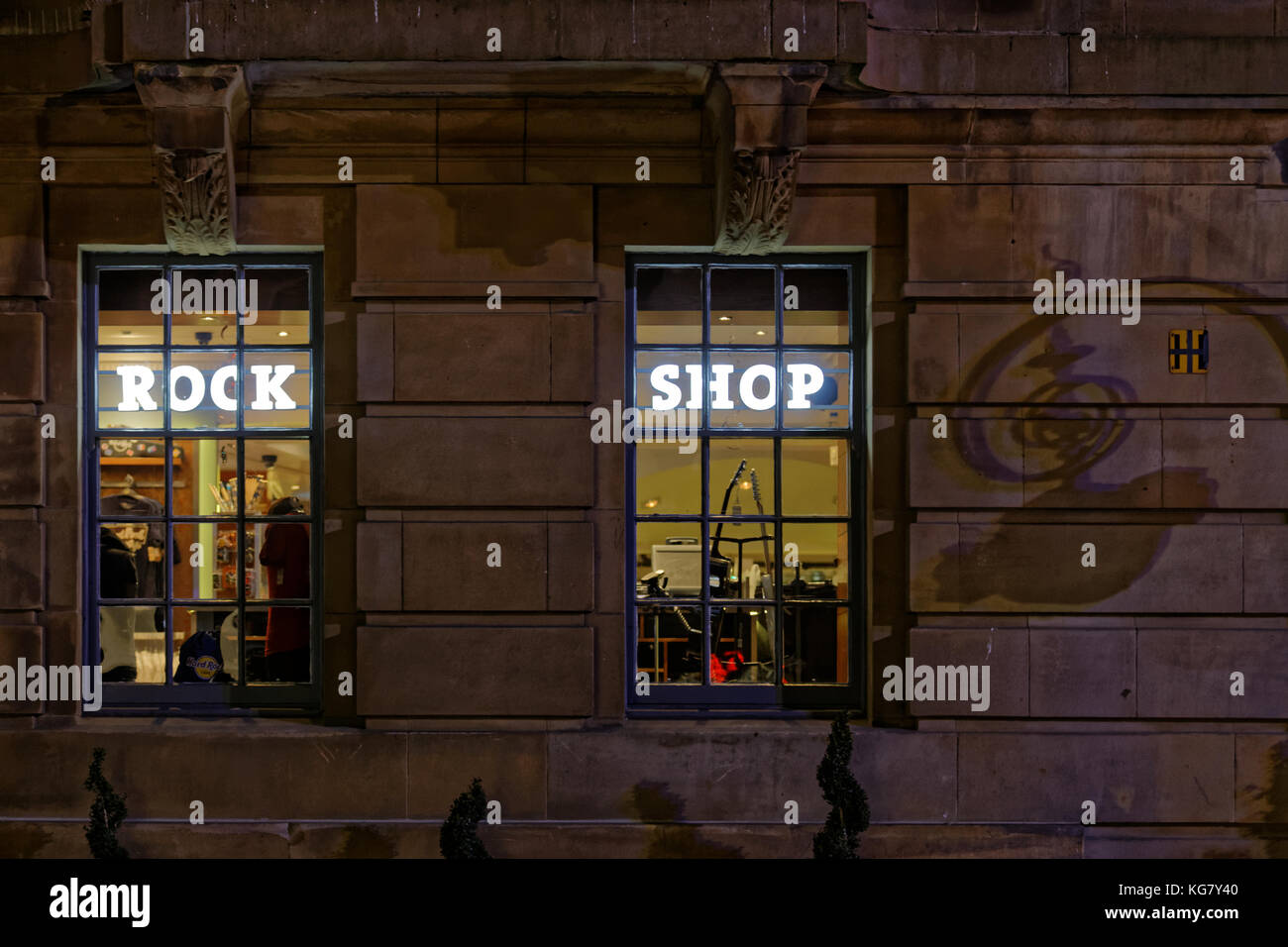 night at the rock shop at the hard rock cafe through street window with the shadow of its street sign Buchanan Street, Glasgow,  United Kingdom Stock Photo