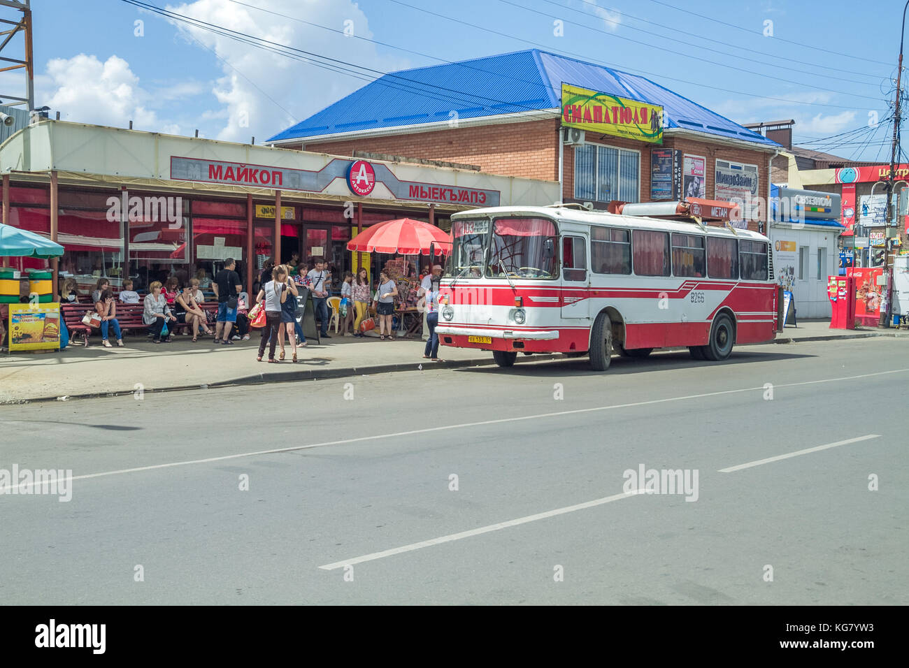 Red retro bus at Russia, city Maikop. Urban street view. Peoples and buildings. 2014 Stock Photo
