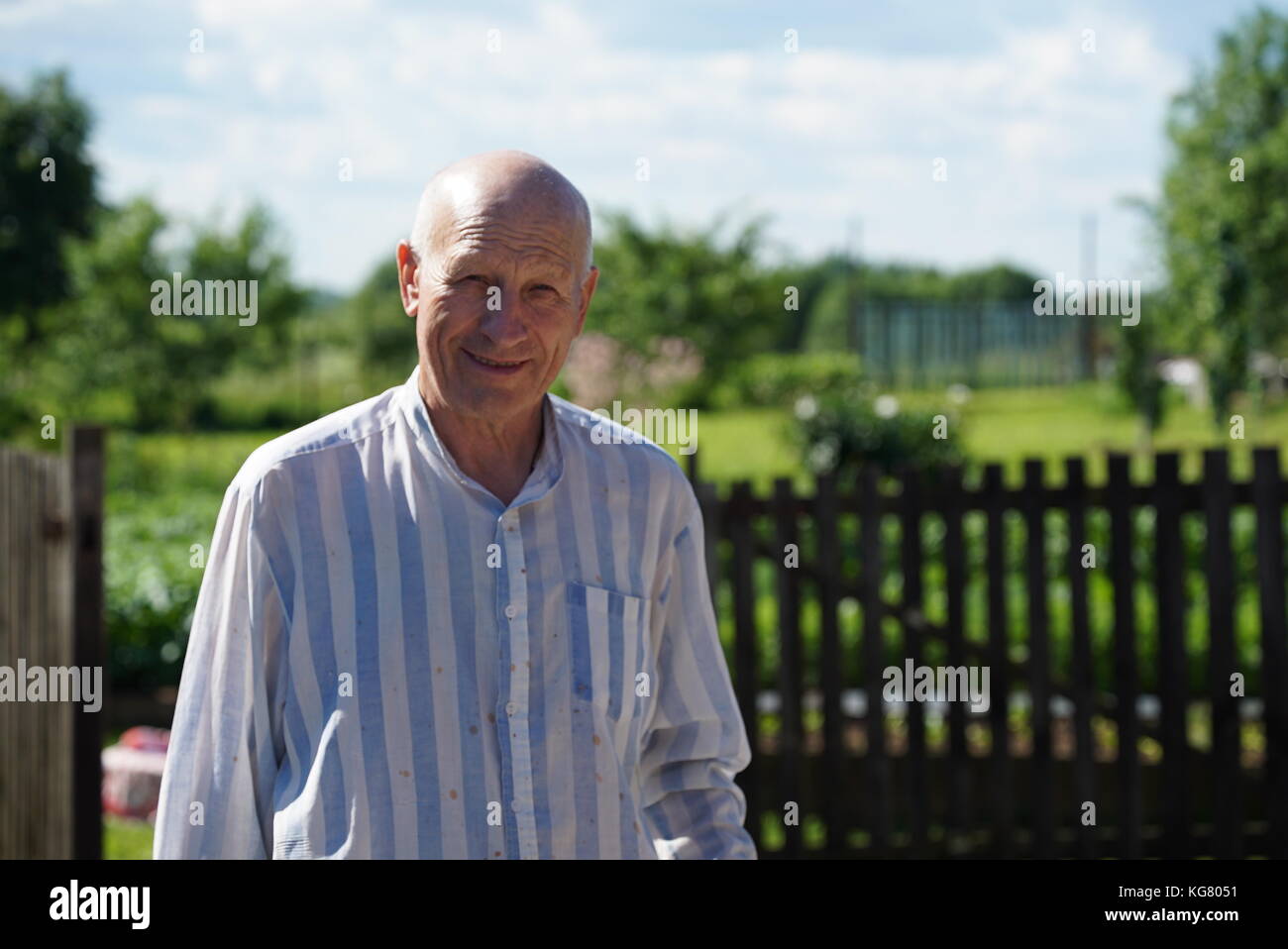 Portrait of mature smiling man farmer dressed in shirt in the ...