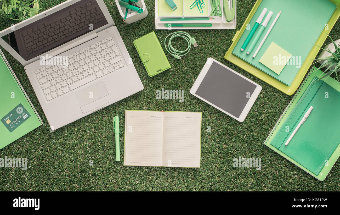 Laptop And Office Supplies On The Grass Blank Organizer At Center Laptop and office supplies on the grass blank organizer at center