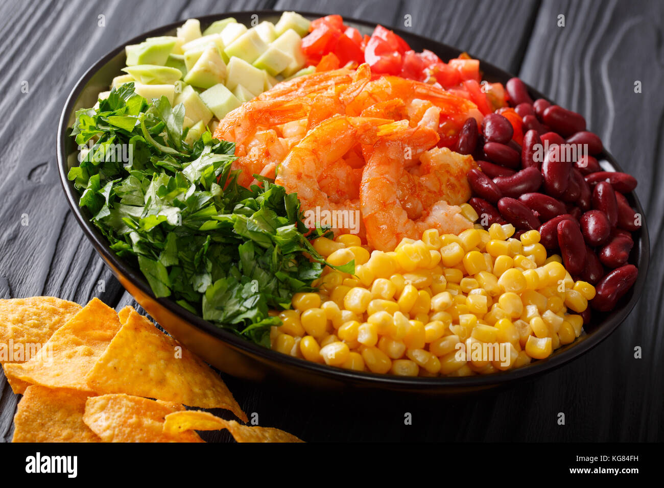 Mexican snack: burrito bowl with shrimp and vegetables close-up on the table. horizontal Stock Photo