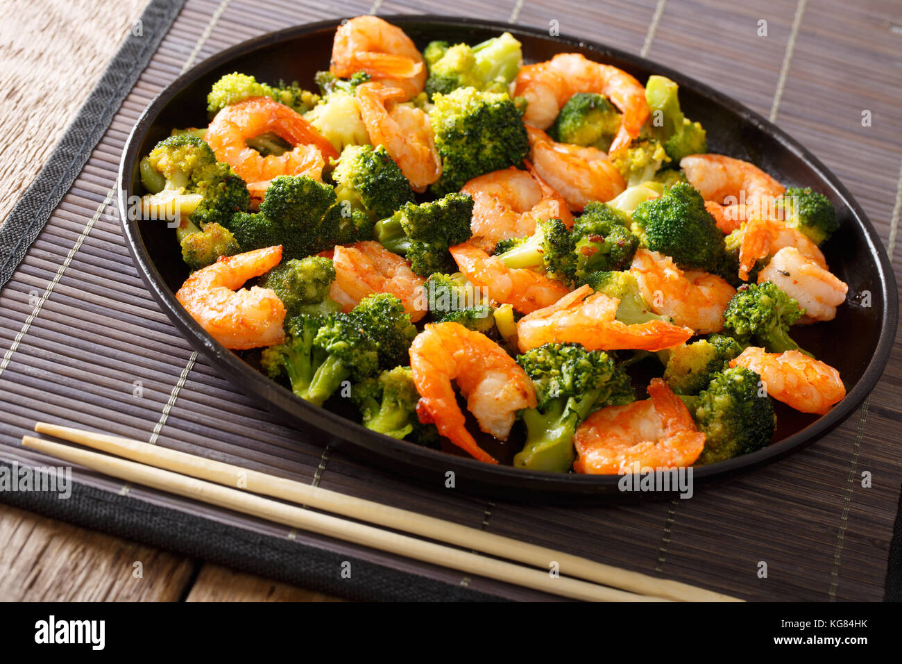 Stir frying shrimp with broccoli closeup on a plate. Horizontal Stock Photo